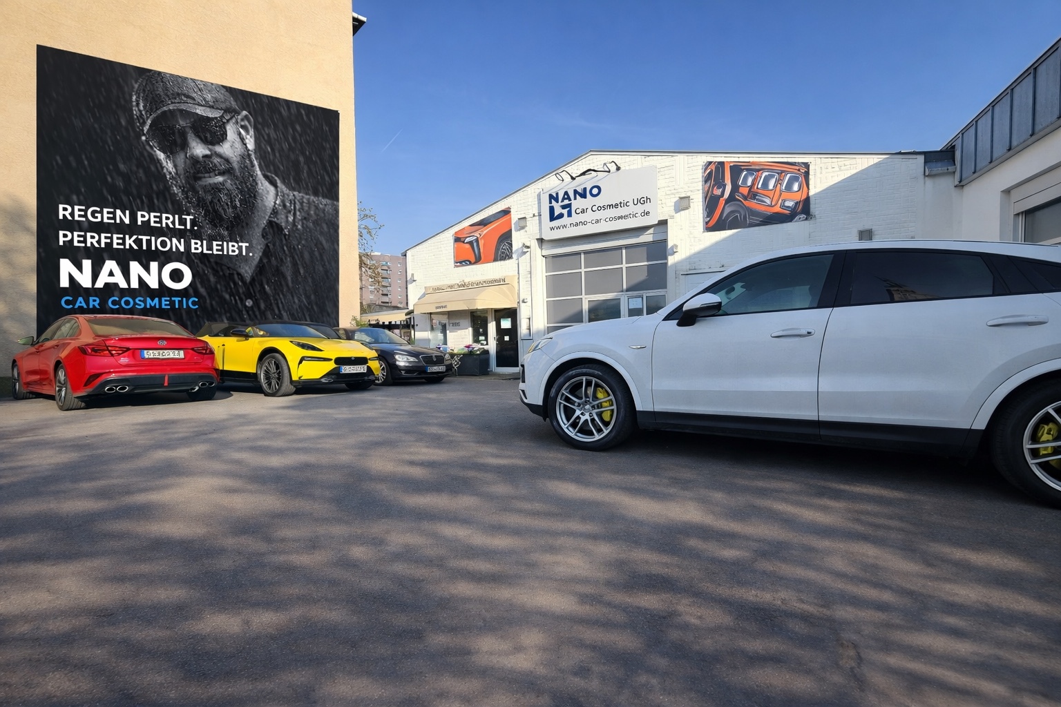 Fahrzeuge auf dem Hof vor Nano Car Cosmetic bei Tageslicht
