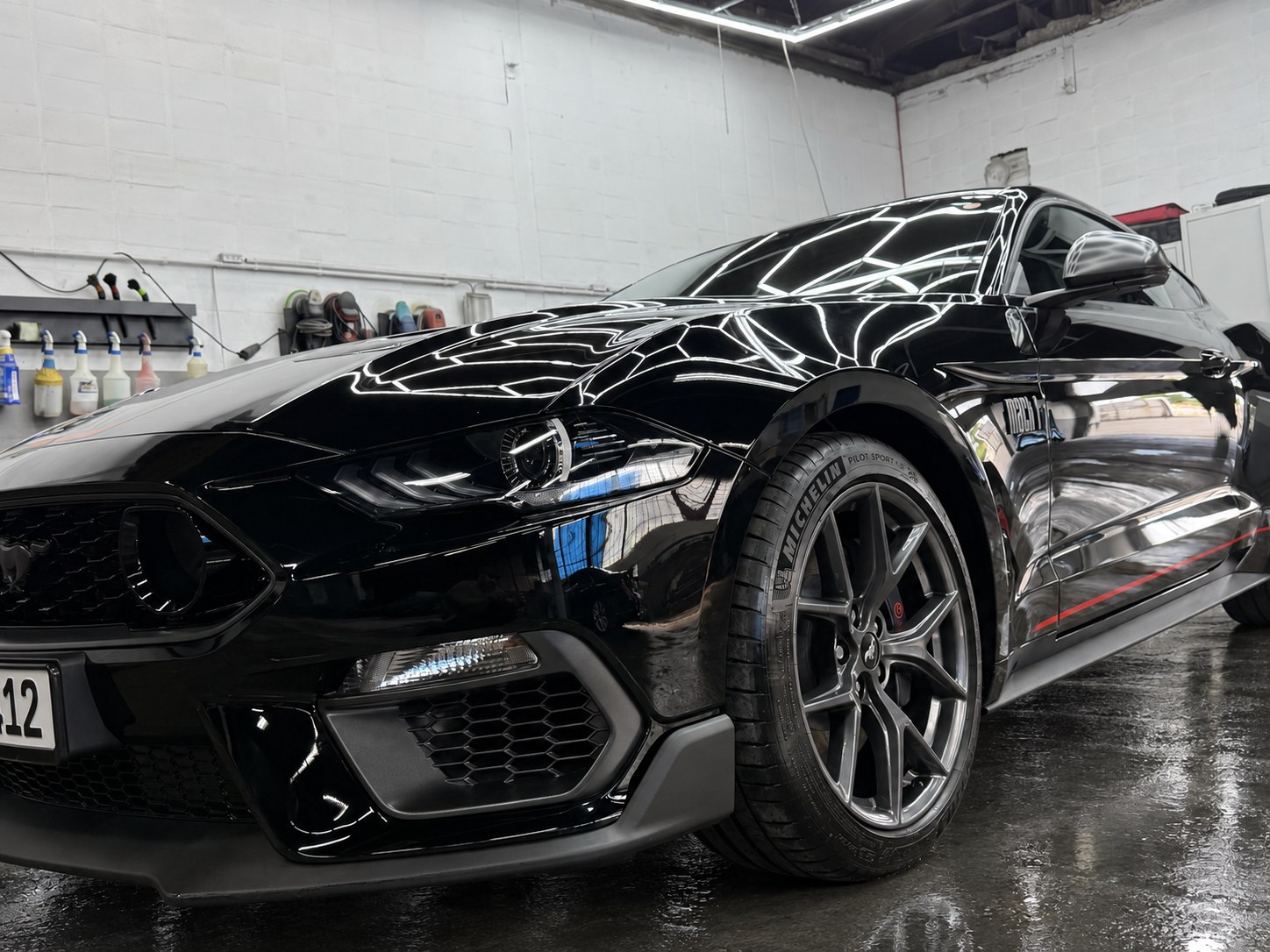 Schwarzer Ford Mustang in der Werkstatt