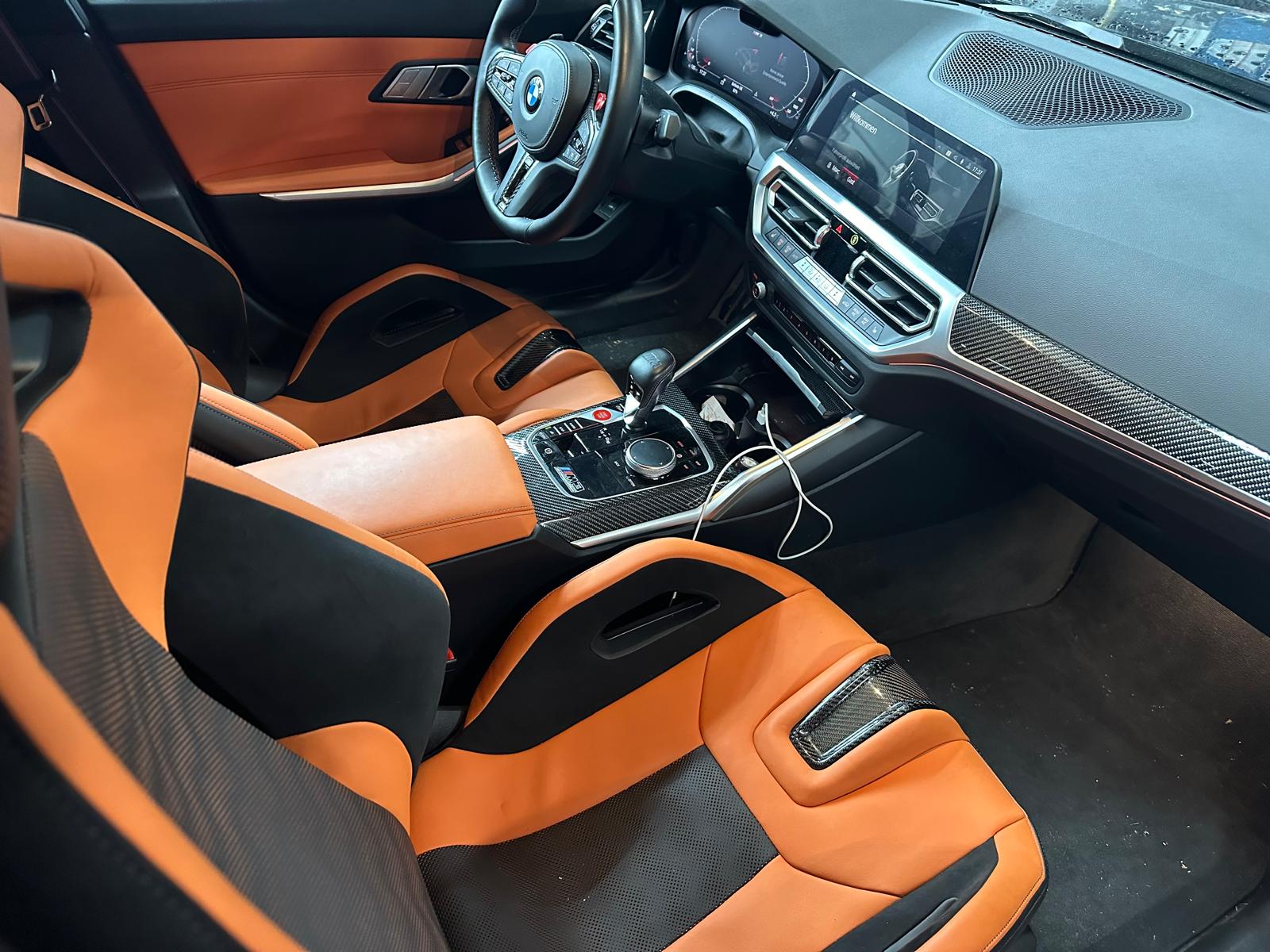 BMW-Innenraum mit orangefarbenen Sportsitzen und Carbon-Details