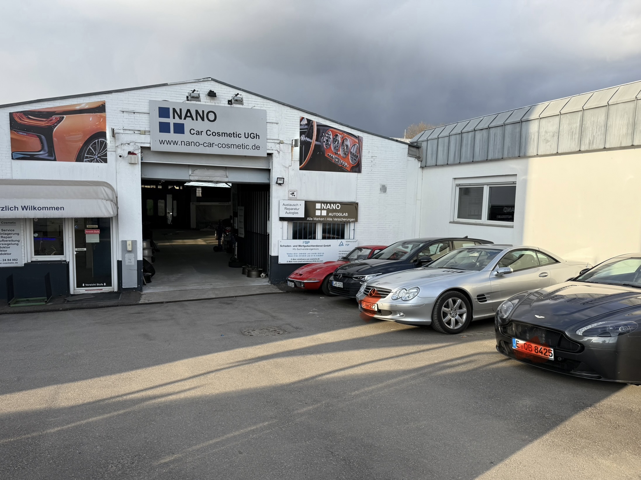 Werkstatteingang von Nano Car Cosmetic in Essen mit mehreren Fahrzeugen auf dem Hof