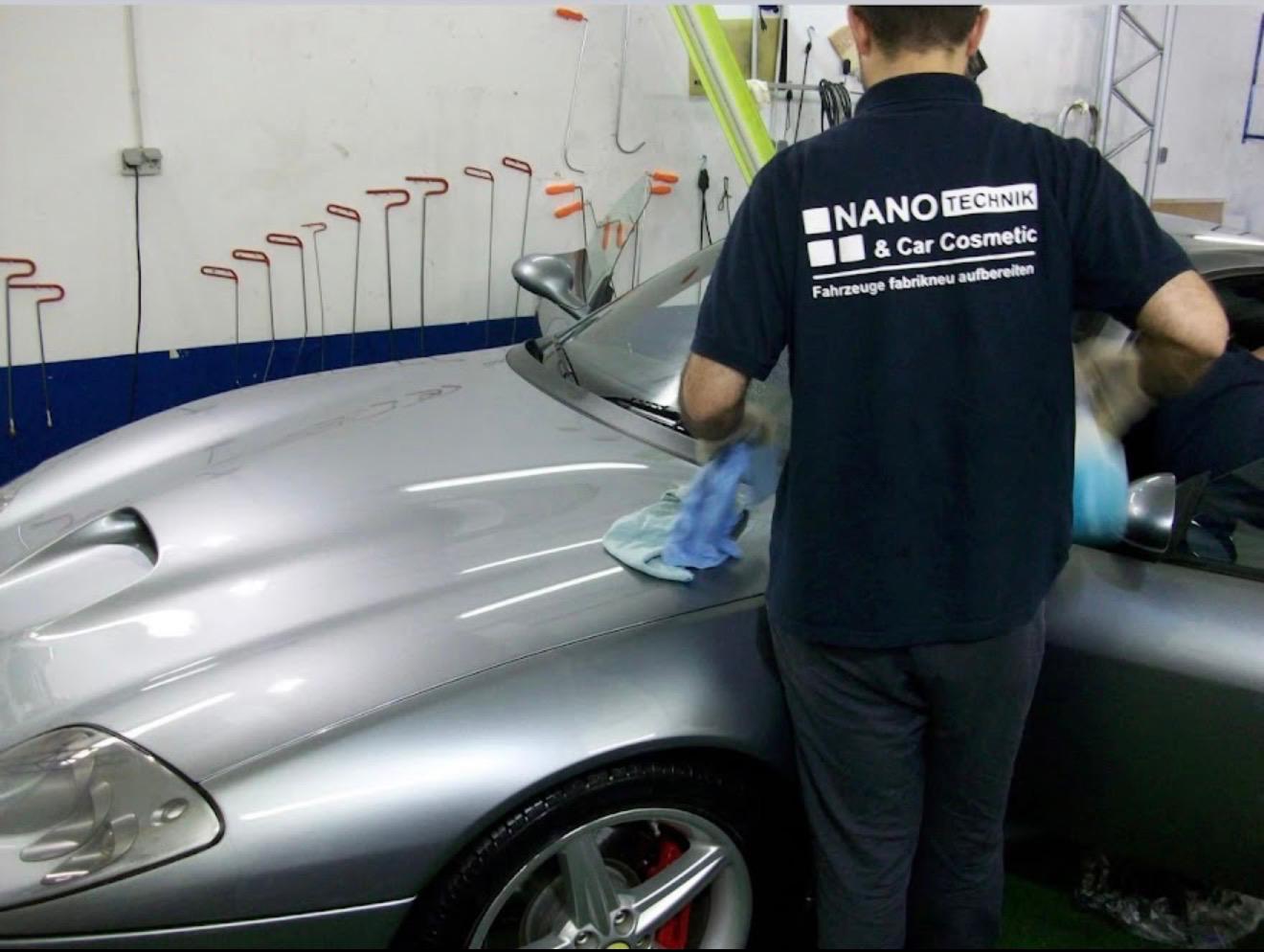 Mitarbeiter von Nano Car Cosmetic bei der Pflege eines silbernen Ferrari in der Werkstatt in Essen